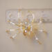 Champagne gold beaded spider sculpture featuring glass beads, pearl details, and a sparkling faceted focal bead.
